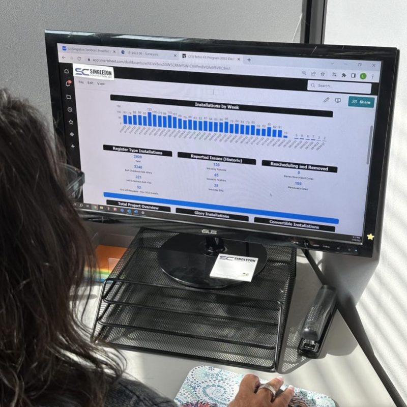 A woman sitting at a desk looking at a computer screen.